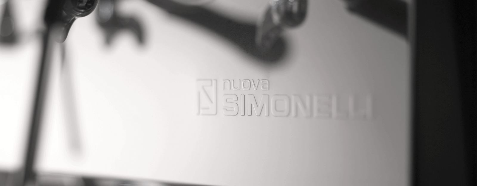Wytłoczone logo Nuova Simonelli na panelu ekspresu z rodziny Appia Life z bliska