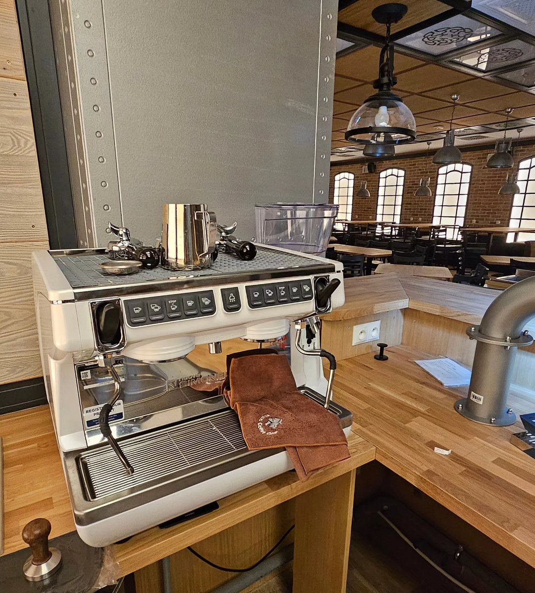 Biały Nuova Simonelli Appia Life Compact na drewnianym barze w Hotelu Juvena